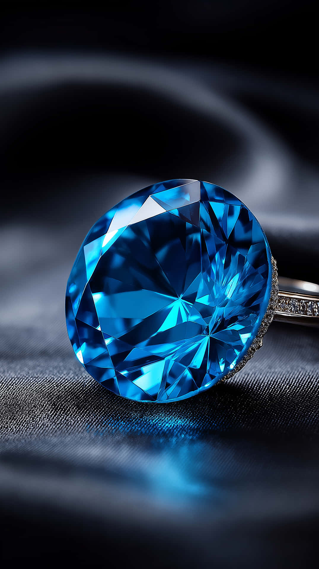 Sapphire Orb Radiance 壁紙 — 一枚令人驚嘆的藍鑽戒指，在深色紋理布料背景上閃耀著銳利的刻面。