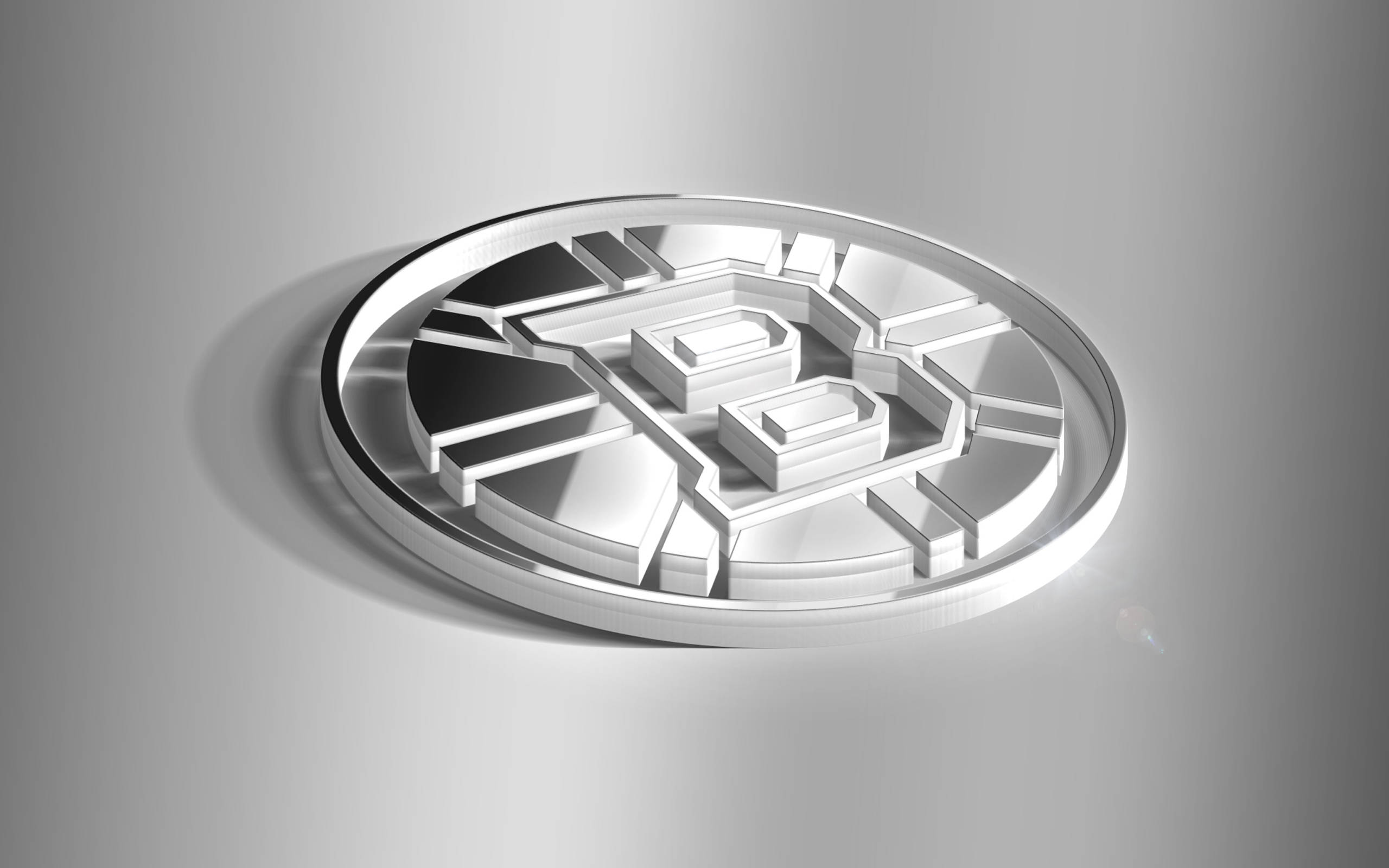 bruins 桌布 壁紙 — 一枚光滑的銀幣，帶有幾何電路圖案，在柔和的攝影棚燈光下放置在漸變灰色表面上。