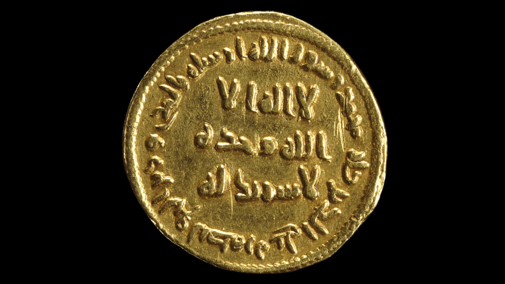 penny 桌布 壁紙 — 一枚刻有阿拉伯文字的古代金幣特寫，背景為純黑色。