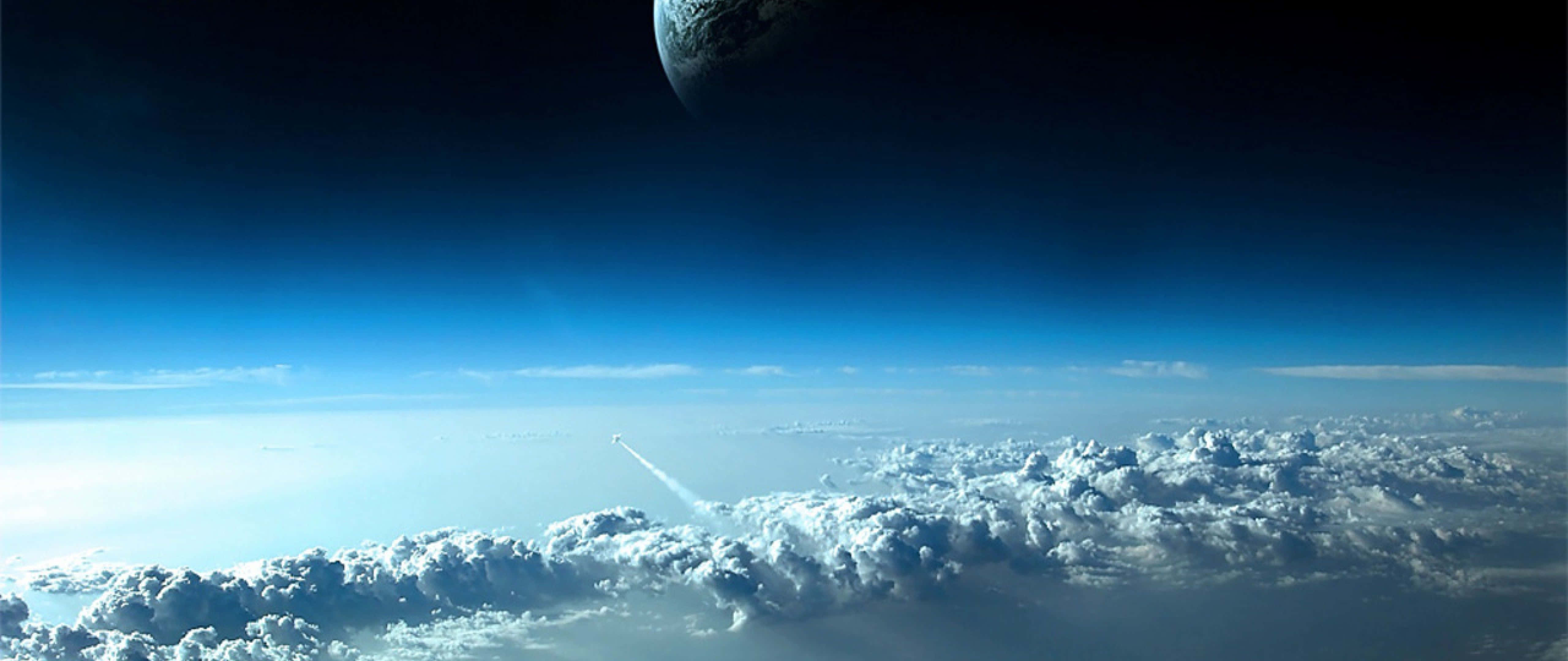wide 桌布 壁紙 — 一枚火箭劃過蓬鬆的白雲，下方是廣闊的藍天，遠處一顆行星隱隱逼近。
