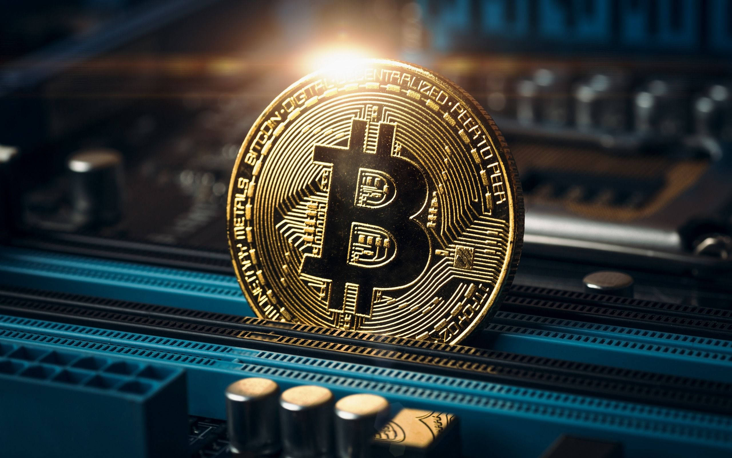 金融 桌布 壁紙 — 一枚金色比特幣硬幣放在藍色電路板上，發光的光線突顯其複雜的電路設計。