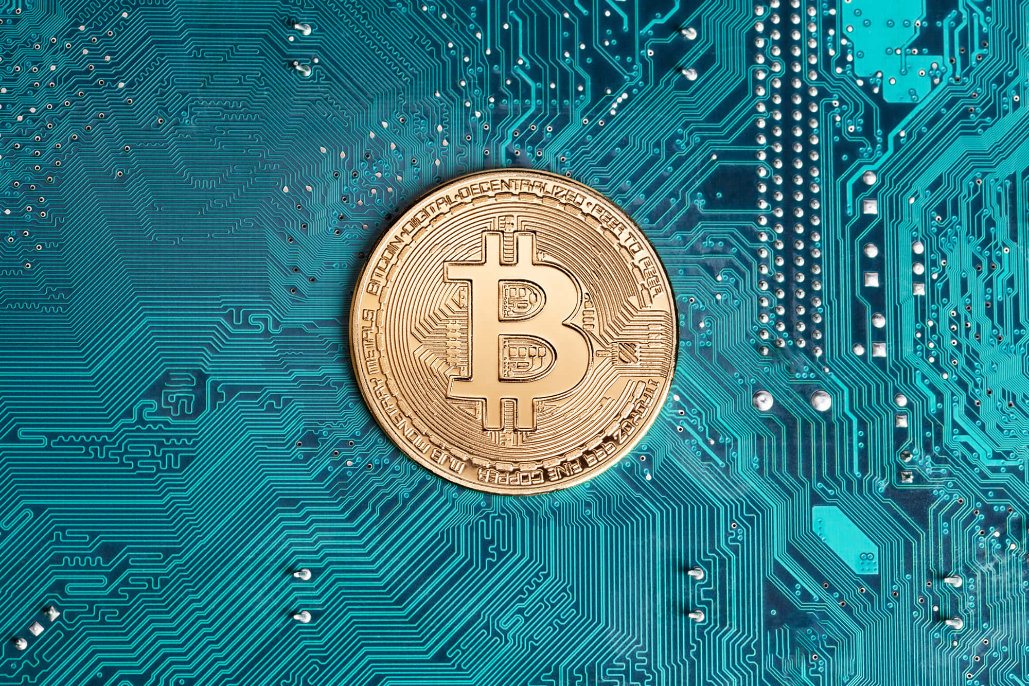 加密貨幣 桌布 壁紙 — 一枚金色比特幣硬幣放在青綠色電路板上，突顯數位金融和加密貨幣技術。