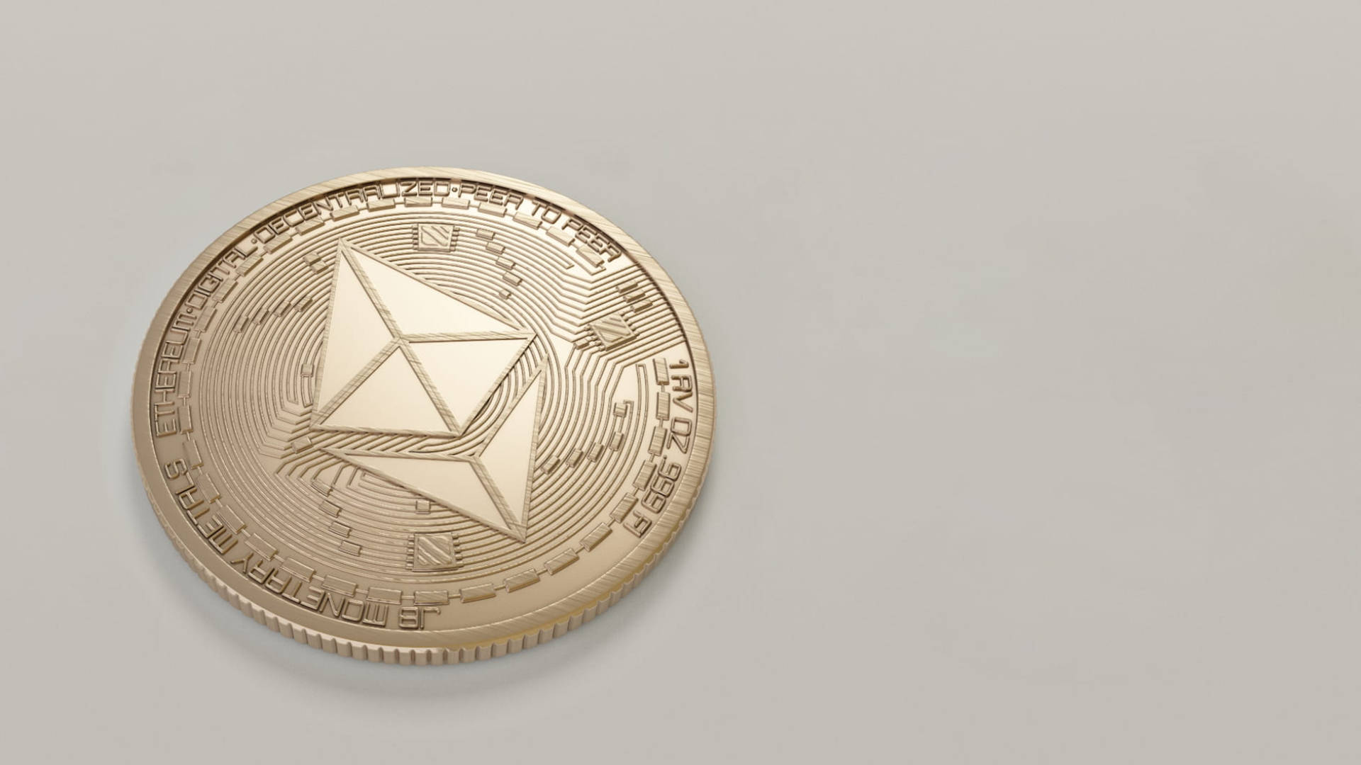 以太坊 桌布 壁紙 — 一枚金色的以太坊加密貨幣硬幣放在帶有柔和陰影的淺灰色平面上。