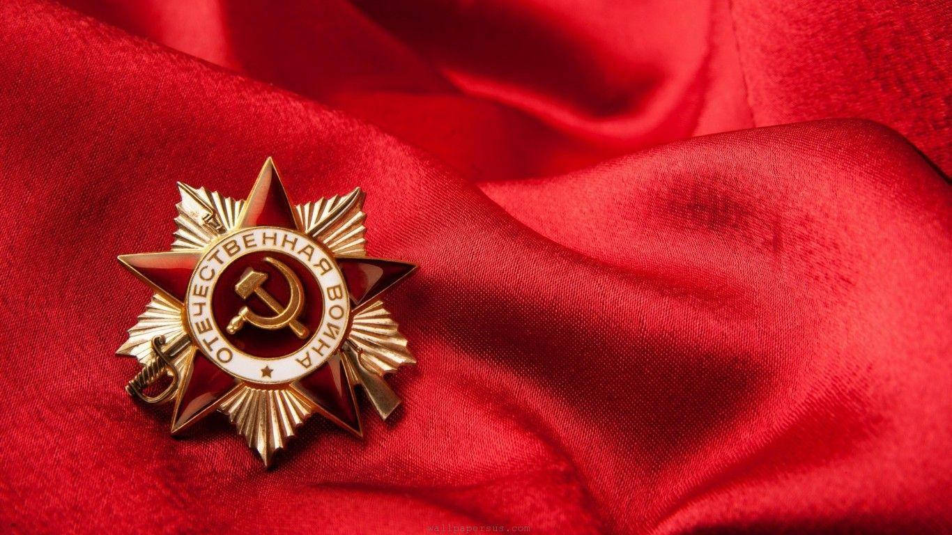 Union 桌布 壁紙 — 一枚金色的紅星勳章獎章放置在帶有戲劇性褶皺和柔和光線的濃郁紅色緞面上。