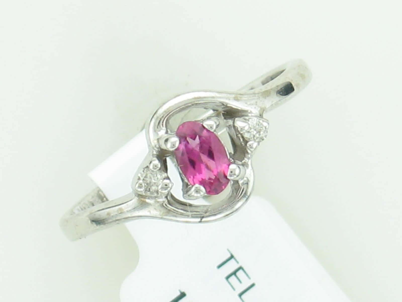 Wedding Ring 桌布 壁紙 — 一枚銀戒指，鑲有鮮豔的粉紅色橢圓形寶石和小鑽石，採用優雅的弧形戒環設計。