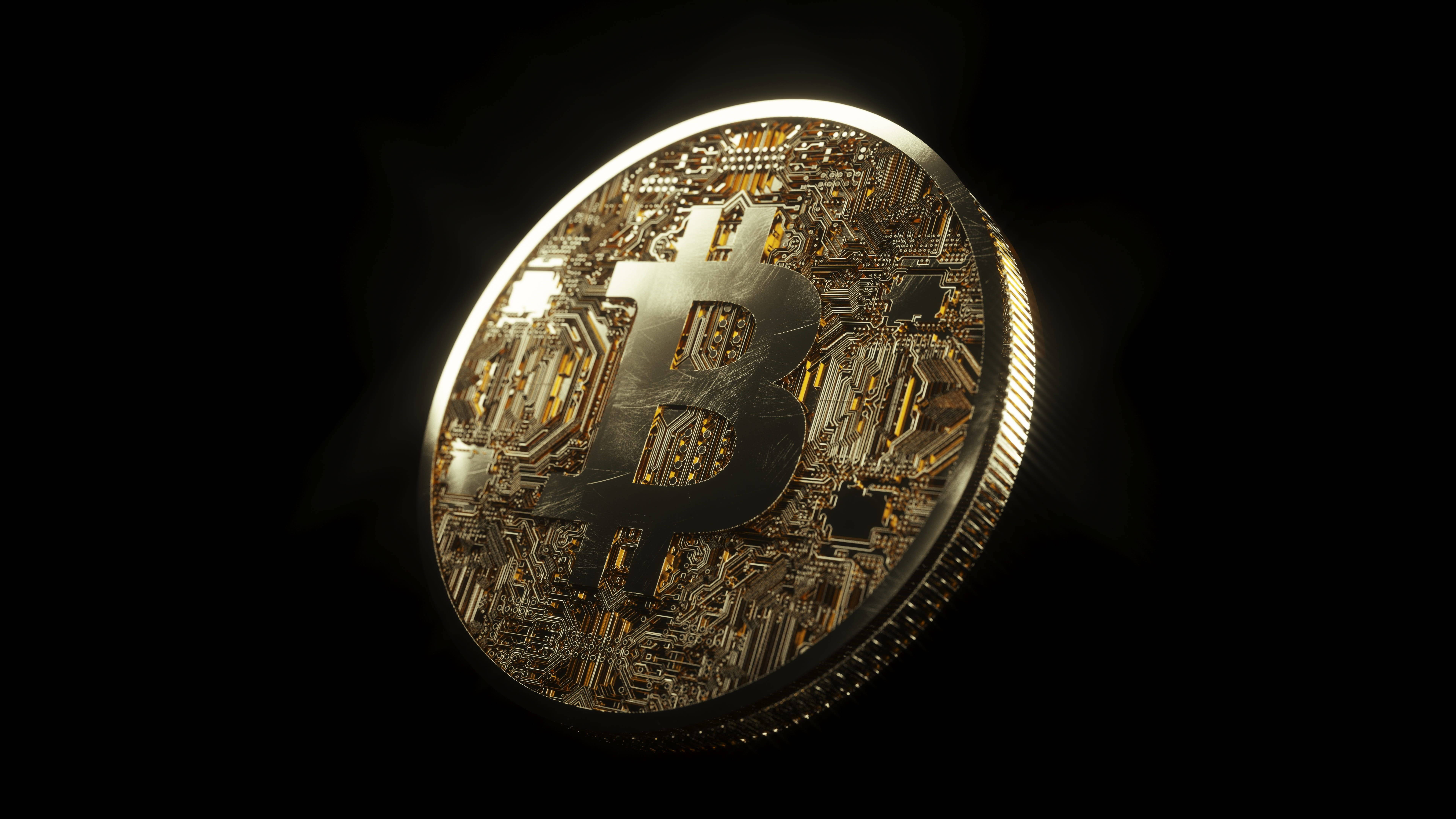 比特幣 桌布 壁紙 — 一枚閃閃發光的金色比特幣硬幣，帶有電路板紋理，在黑色背景上發光。