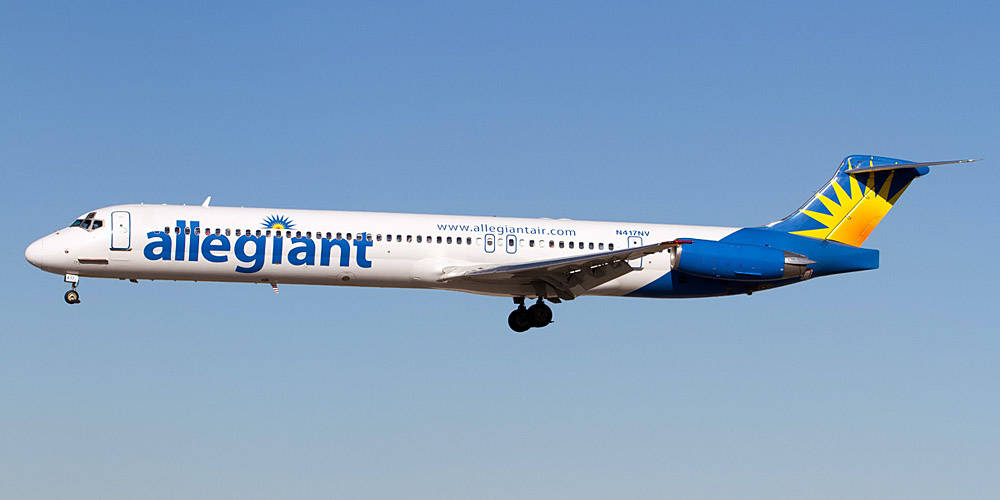 飛機 桌布 壁紙 — 一架 Allegiant Air 藍黃塗裝的客機在清澈的藍天中優雅地傾斜轉彎。