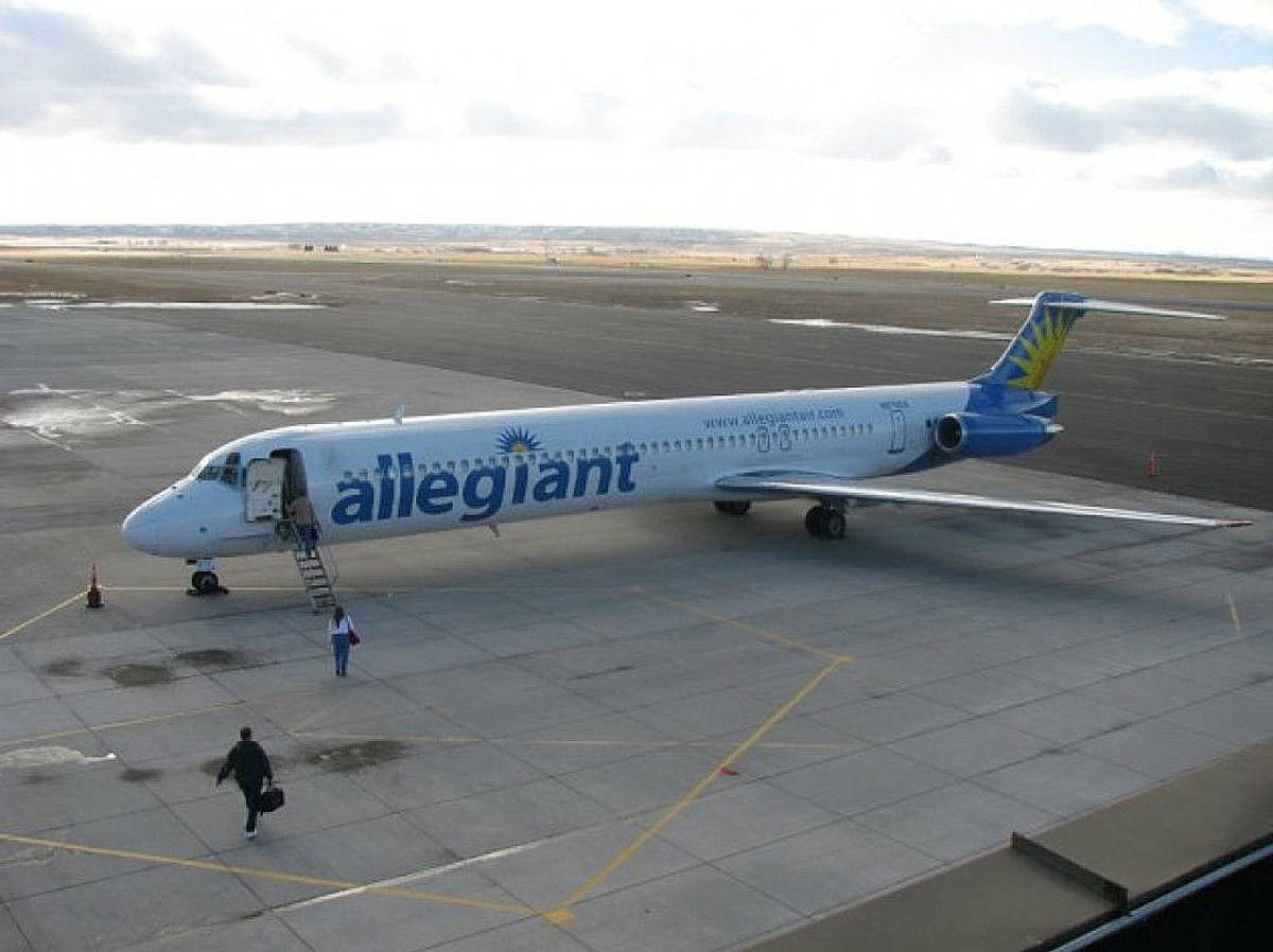 transportation 桌布 壁紙 — 一架 Allegiant Air 客機停在停機坪上，乘客在陰天透過樓梯登機。