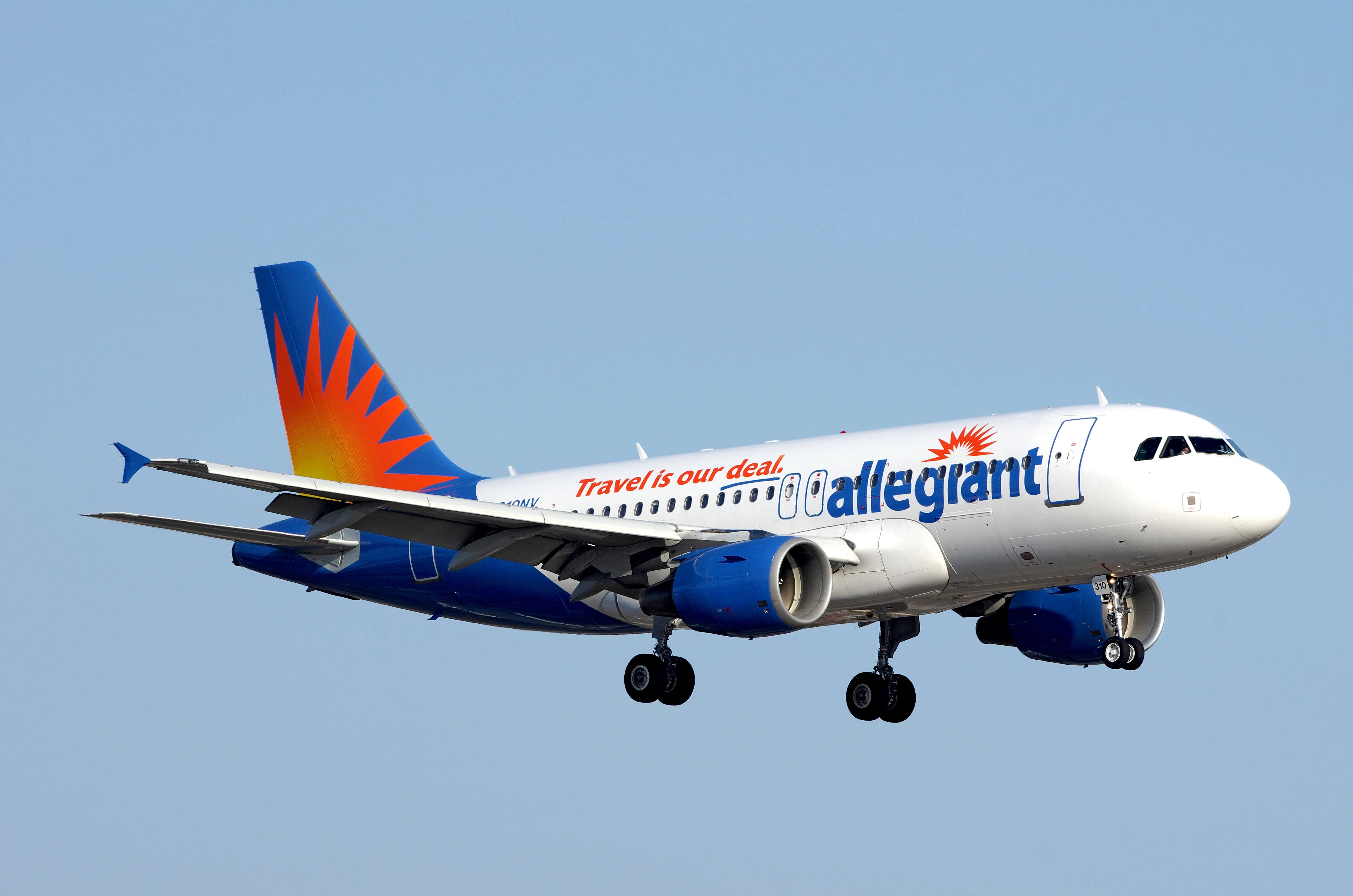 transportation 桌布 壁紙 — 一架 Allegiant Airlines 噴射機帶有旭日尾翼設計，在日間飛行中對著晴朗藍天傾斜。