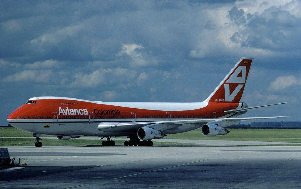 Airport 桌布 壁紙 — 一架 Avianca Colombia 波音 747 在戲劇性的多雲天空下滑行在跑道上。