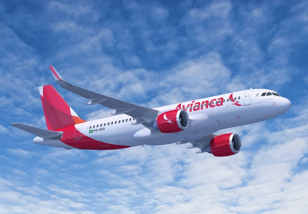  壁紙 — 一架 Avianca 客機在晴朗的藍天中翱翔，天空點綴著蓬鬆的白雲。