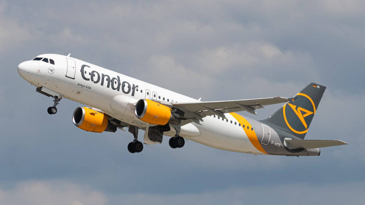 雲朵 桌布 壁紙 — 一架 Condor Airlines 的空中巴士 A320，配備黃色引擎和尾部標誌，在陰天中攀升。