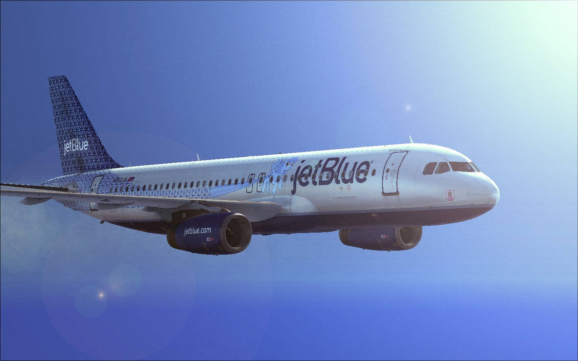 Plane 桌布 壁紙 — 一架 JetBlue 飛機在晴朗的藍天中翱翔，明亮的陽光產生鏡頭光暈。