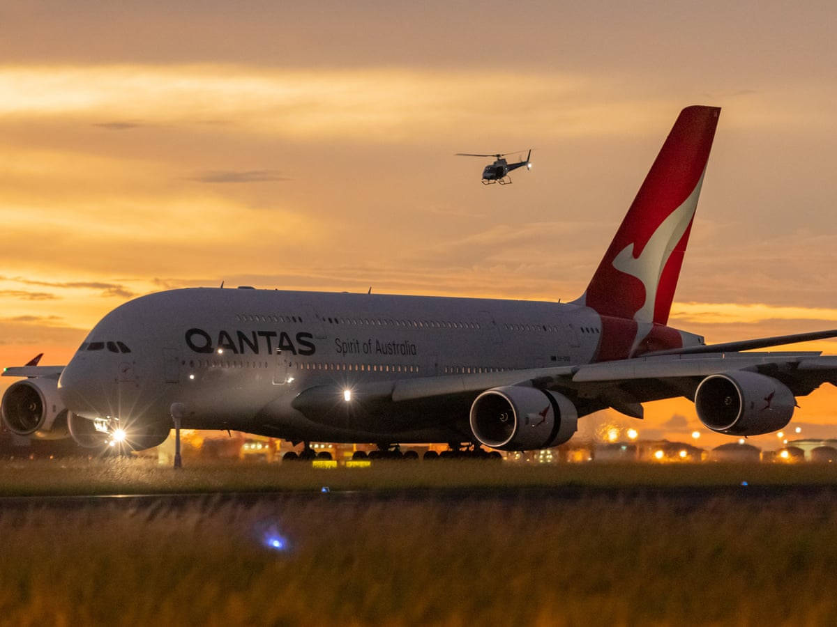 飛機 桌布 壁紙 — 一架 Qantas Airbus A380 'Spirit of Australia' 在日落時滑行，一架直升機在金色天空下飛過頭頂。