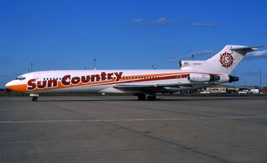 Airport 桌布 壁紙 — 一架 Sun Country Airlines 的 Tristar 噴射機停泊在陽光明媚的機場停機坪上，天空清澈湛藍。