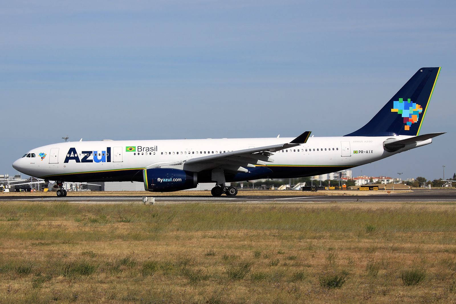 飛機 桌布 壁紙 — 一架Azul Brazil的空中巴士A330在乾草和機場建築物的跑道上滑行，天空清澈湛藍。