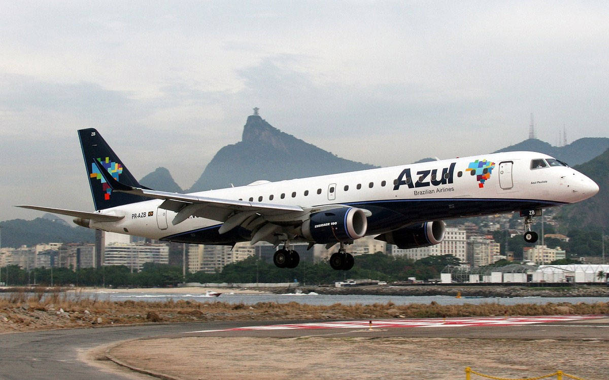 巴西 桌布 壁紙 — 一架Azul巴西航空公司的飛機從跑道起飛，背景是糖麵包山和城市天際線，天空多雲。
