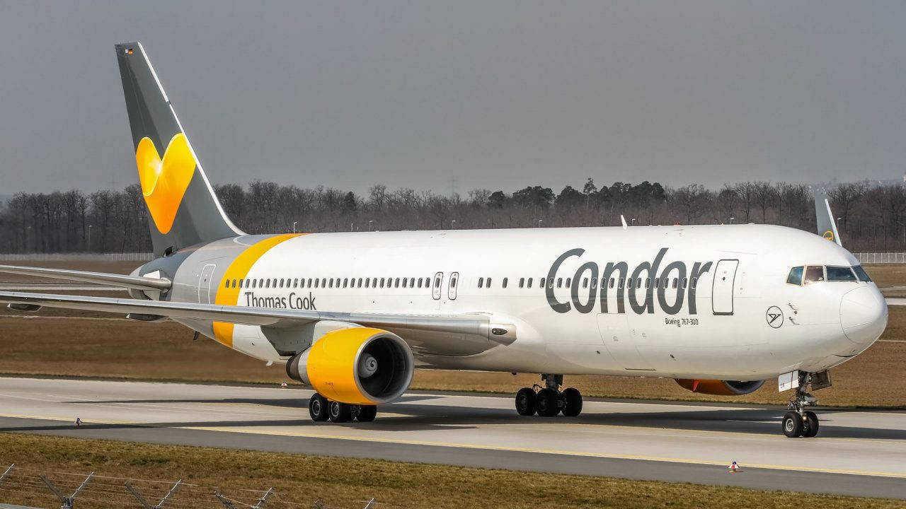 Airport 桌布 壁紙 — 一架Condor Thomas Cook波音767-300飛機在跑道上滑行，背景是光禿禿的樹木和陰天。