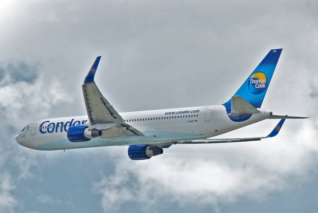 飛機 桌布 壁紙 — 一架Condor Thomas Cook飛機在藍白塗裝的多雲天空中翱翔。