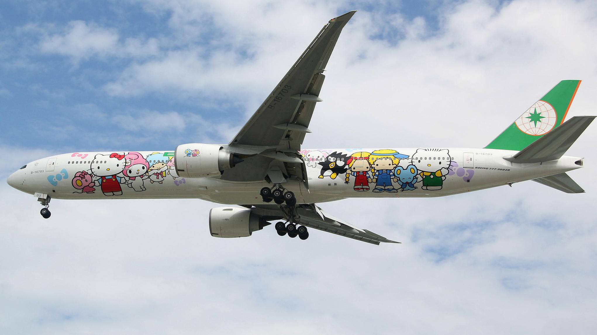 transportation 桌布 壁紙 — 一架Hello Kitty主題飛機在點綴著蓬鬆白雲的明亮藍天中翱翔。