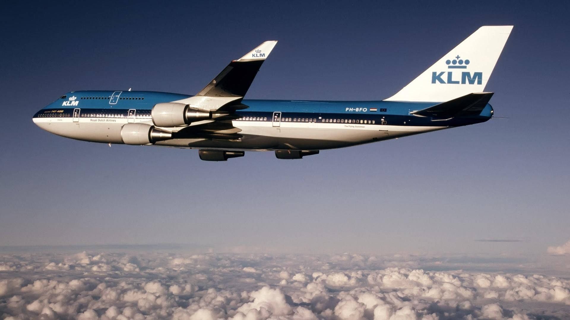 飛機 桌布 壁紙 — 一架KLM波音747在晴朗藍天下翱翔於蓬鬆白雲之上。
