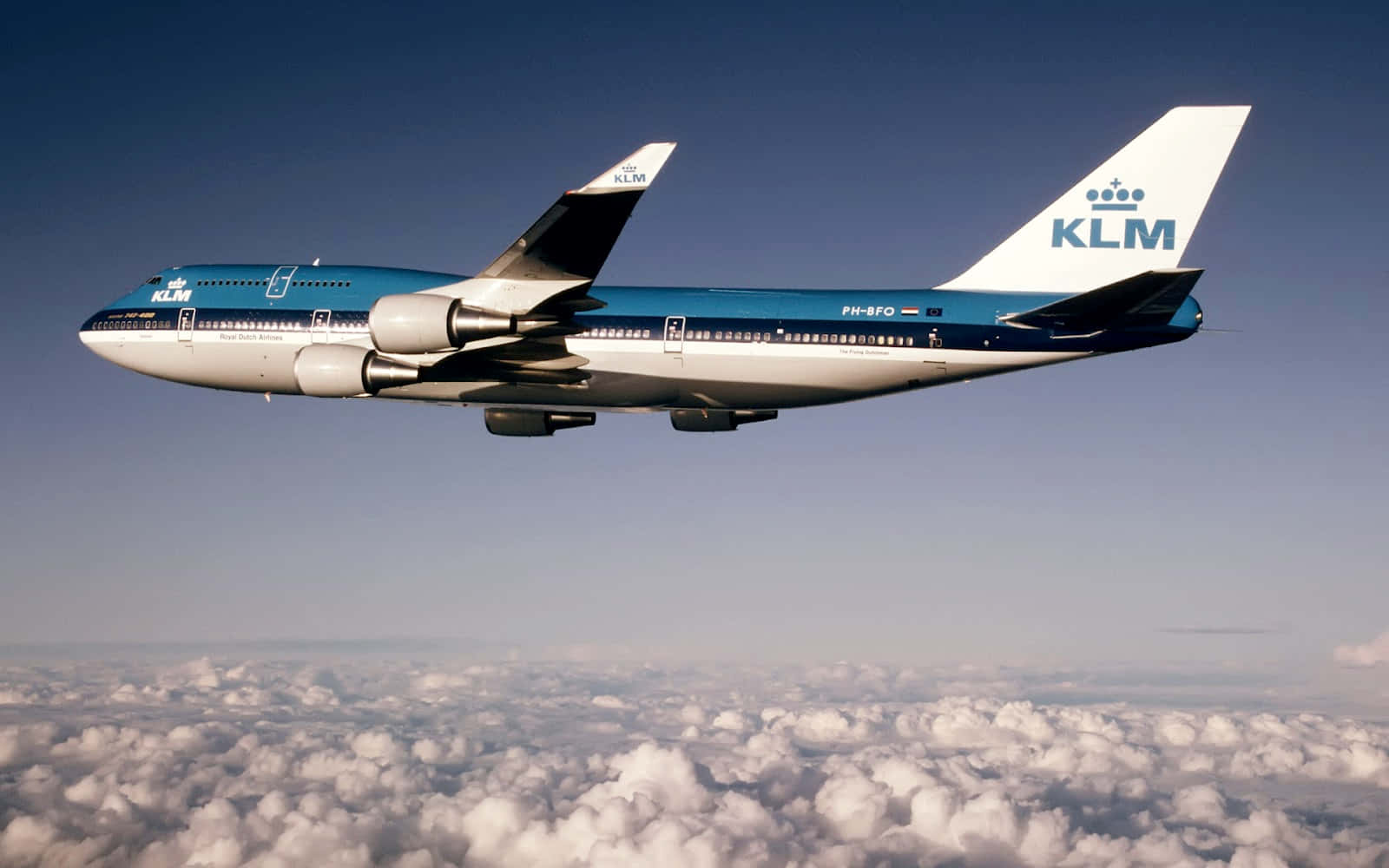 飛機 桌布 壁紙 — 一架KLM波音747在晴朗藍天下優雅地翱翔於一片蓬鬆白雲之上。