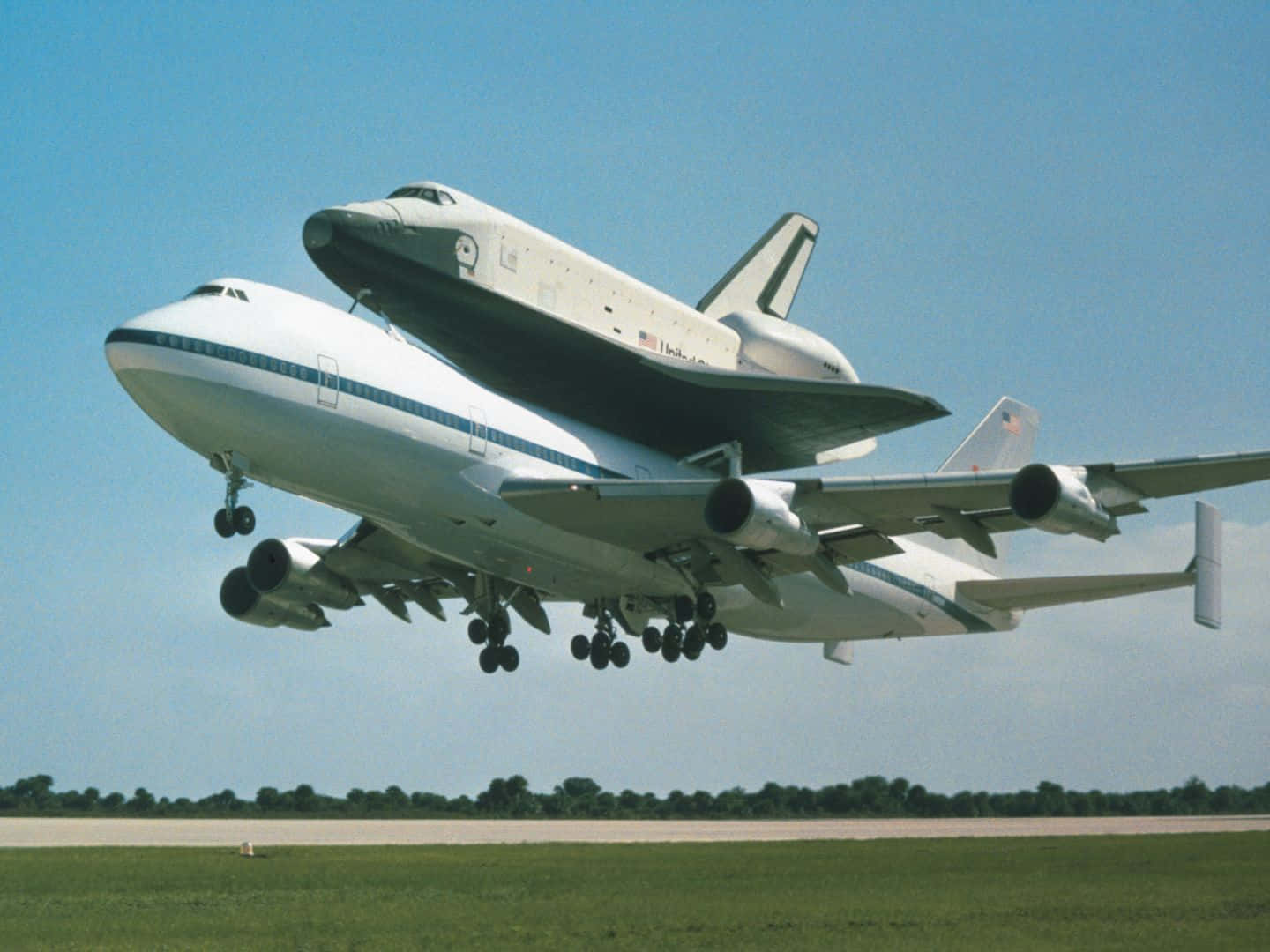 Aircraft 桌布 壁紙 — 一架NASA太空梭安裝在改裝的波音747飛機上，在晴朗藍天下於日間起飛。