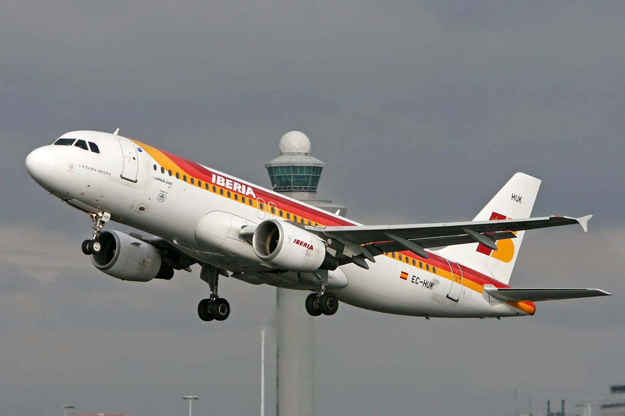  壁紙 — 一架伊比利亞航空空中巴士A320在陰天中起飛，背景有機場控制塔。