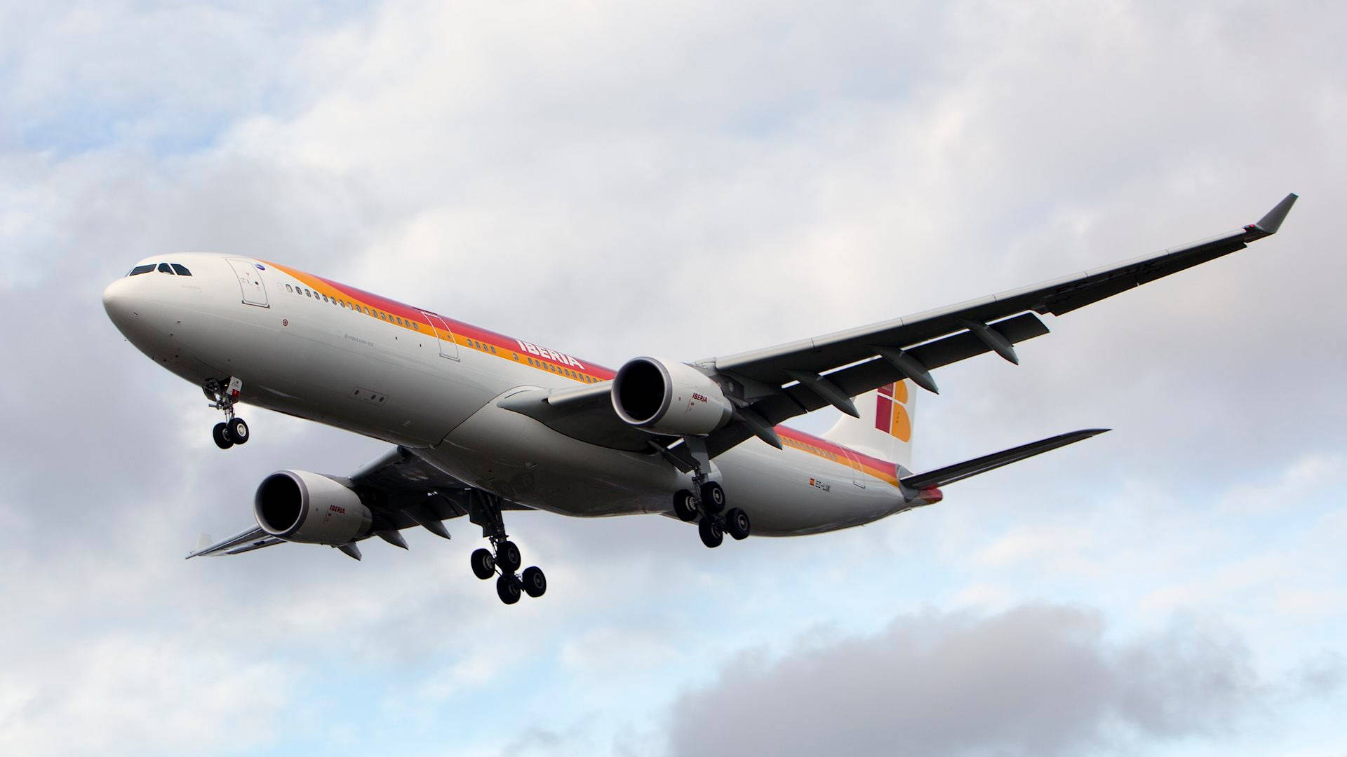 飛機 桌布 壁紙 — 一架伊比利亞航空空中巴士A330在多雲的天空下放下起落架下降中。