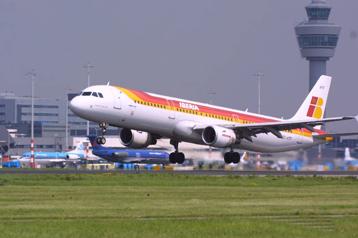 飛機 桌布 壁紙 — 一架伊比利亞航空空中巴士A330從跑道起飛，背景可見控制塔及機場建築物。