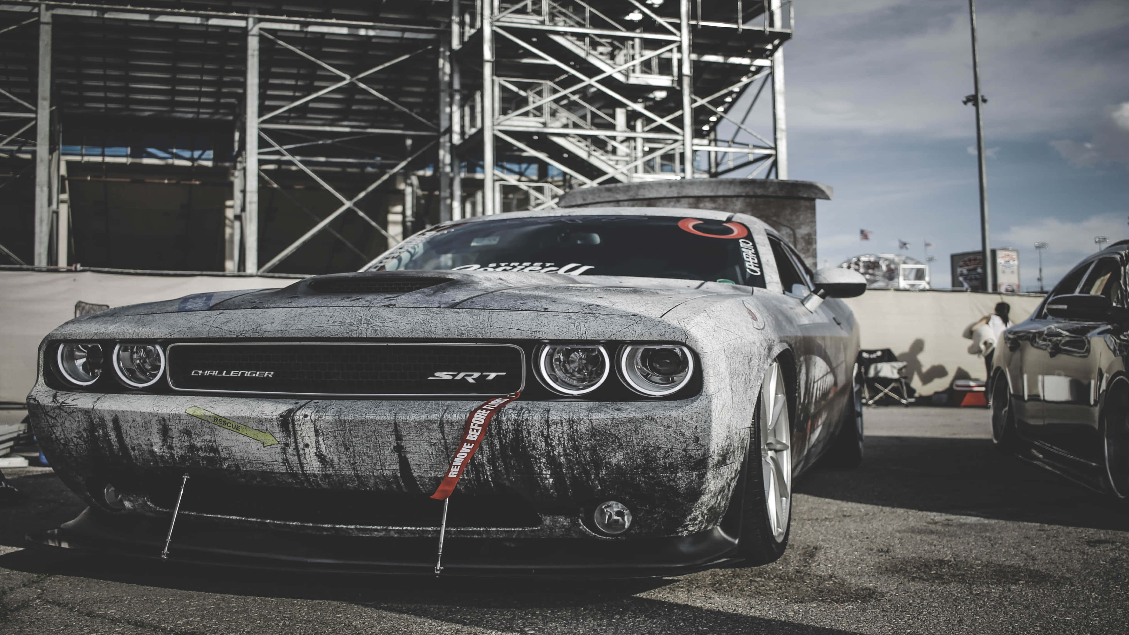 4K汽車 桌布 壁紙 — 一架佈滿污垢和泥濘的黑色 Dodge Challenger SRT 在陰天下的賽道上蓄勢待發。