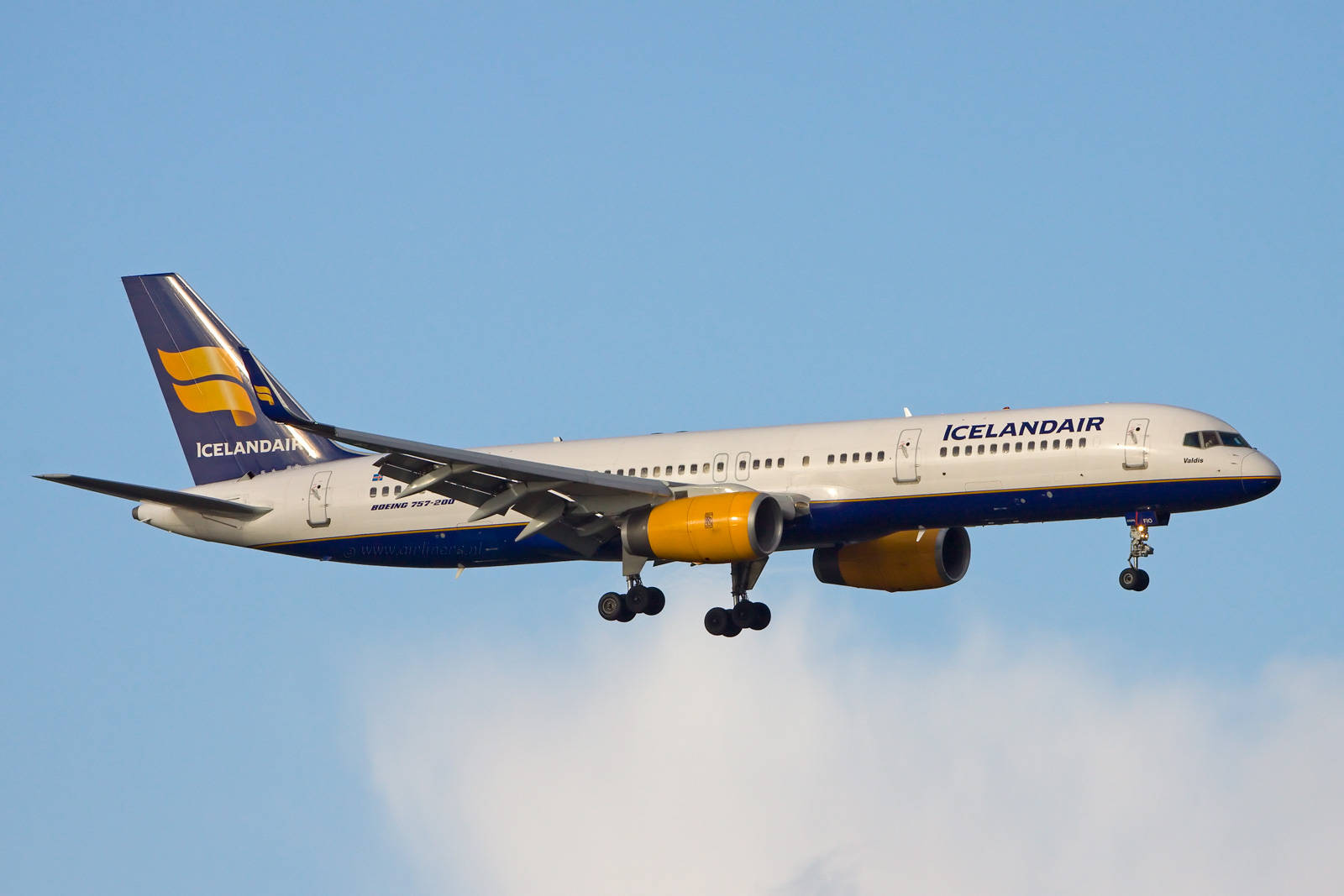  壁紙 — 一架冰島航空波音757-200飛機放下起落架，在清澈藍天和柔軟白雲中翱翔。