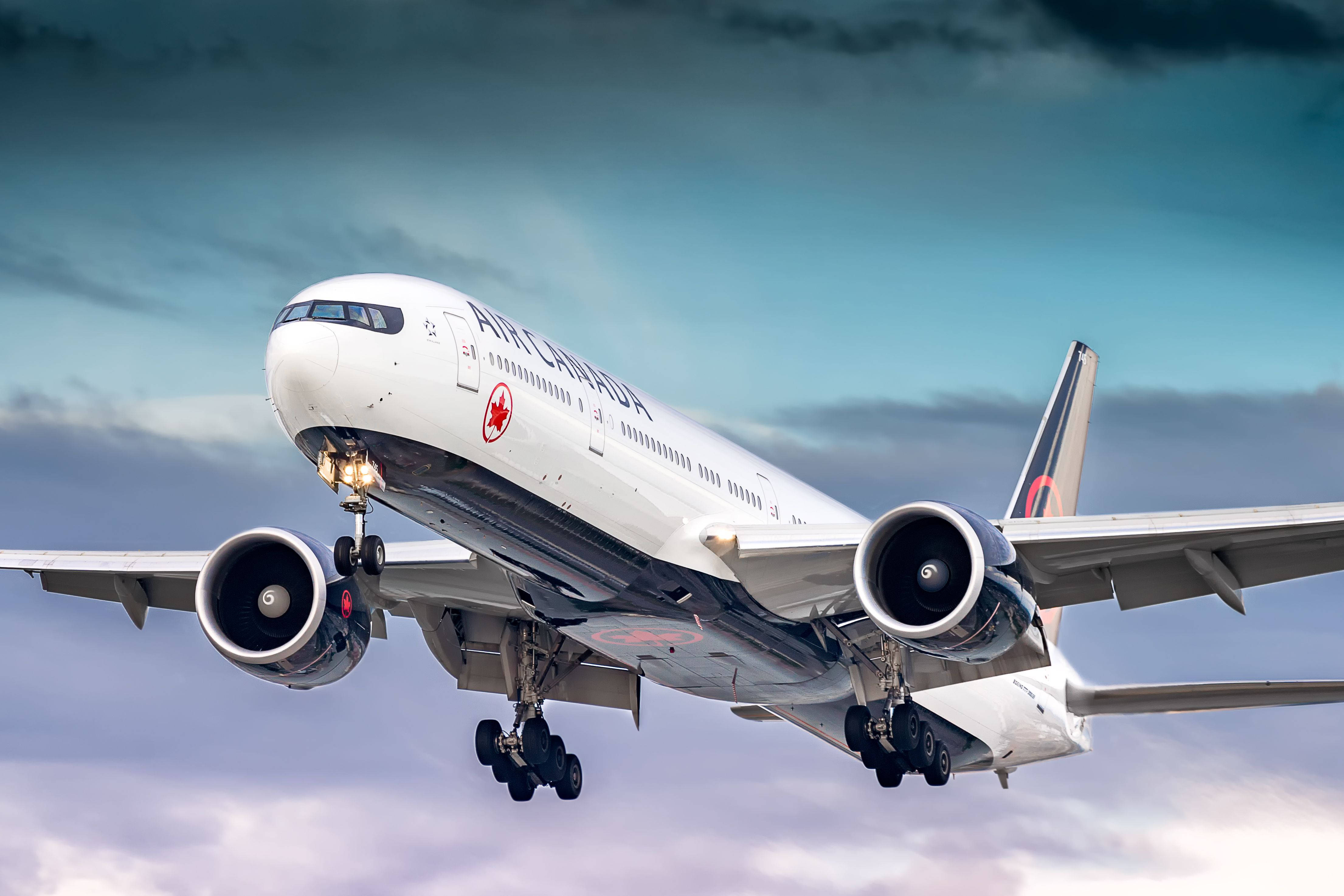 飛機 桌布 壁紙 — 一架加拿大航空波音777在戲劇性的多雲天空背景下放下起落架下降。