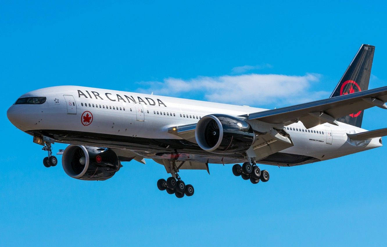 Plane 桌布 壁紙 — 一架加拿大航空波音777在晴朗藍天和零星白雲中下降。