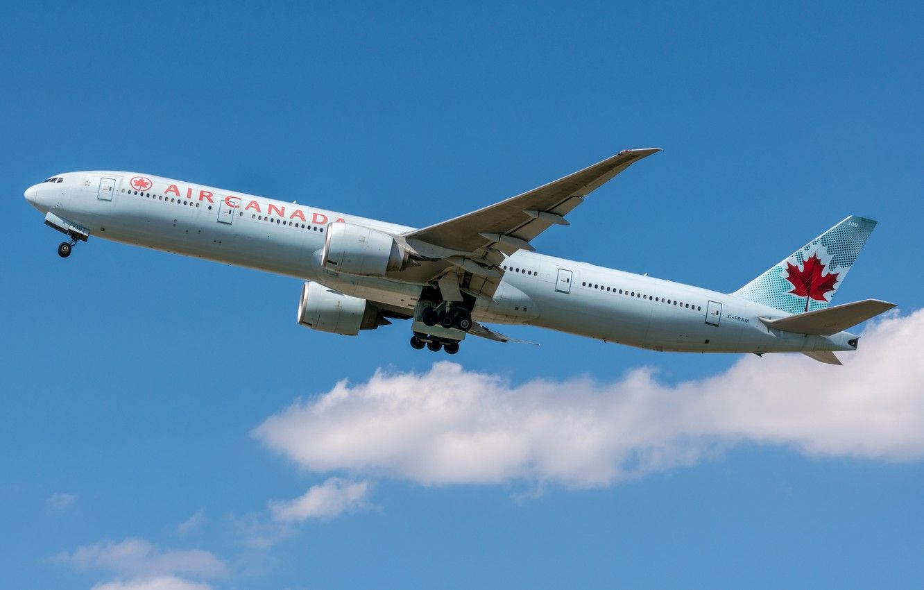 Plane 桌布 壁紙 — 一架加拿大航空波音777在晴朗藍天和機翼下蓬鬆白雲的襯托下下降。