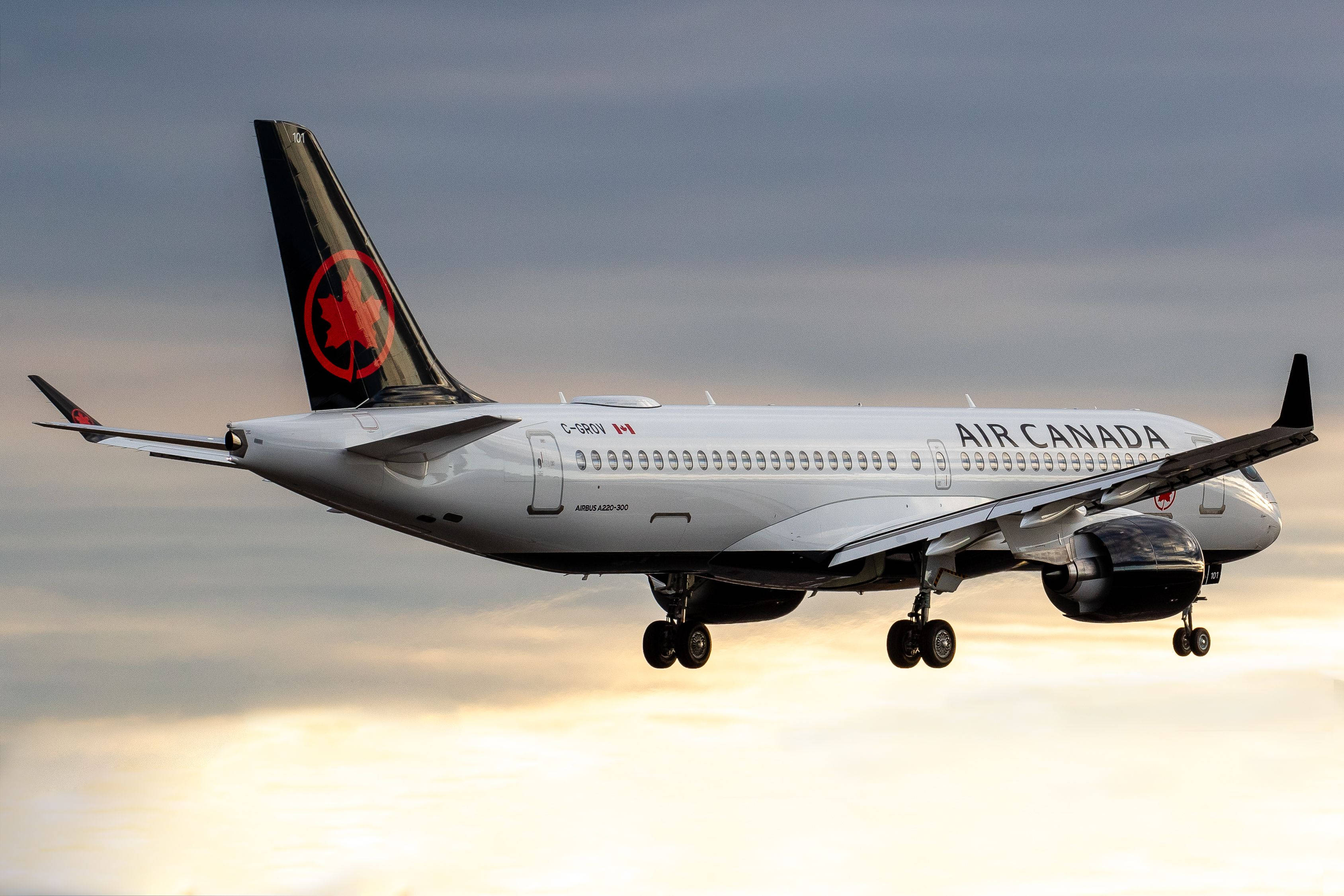 Plane 桌布 壁紙 — 一架加拿大航空飛機在下方有雲的柔和金色日落天空中下降。
