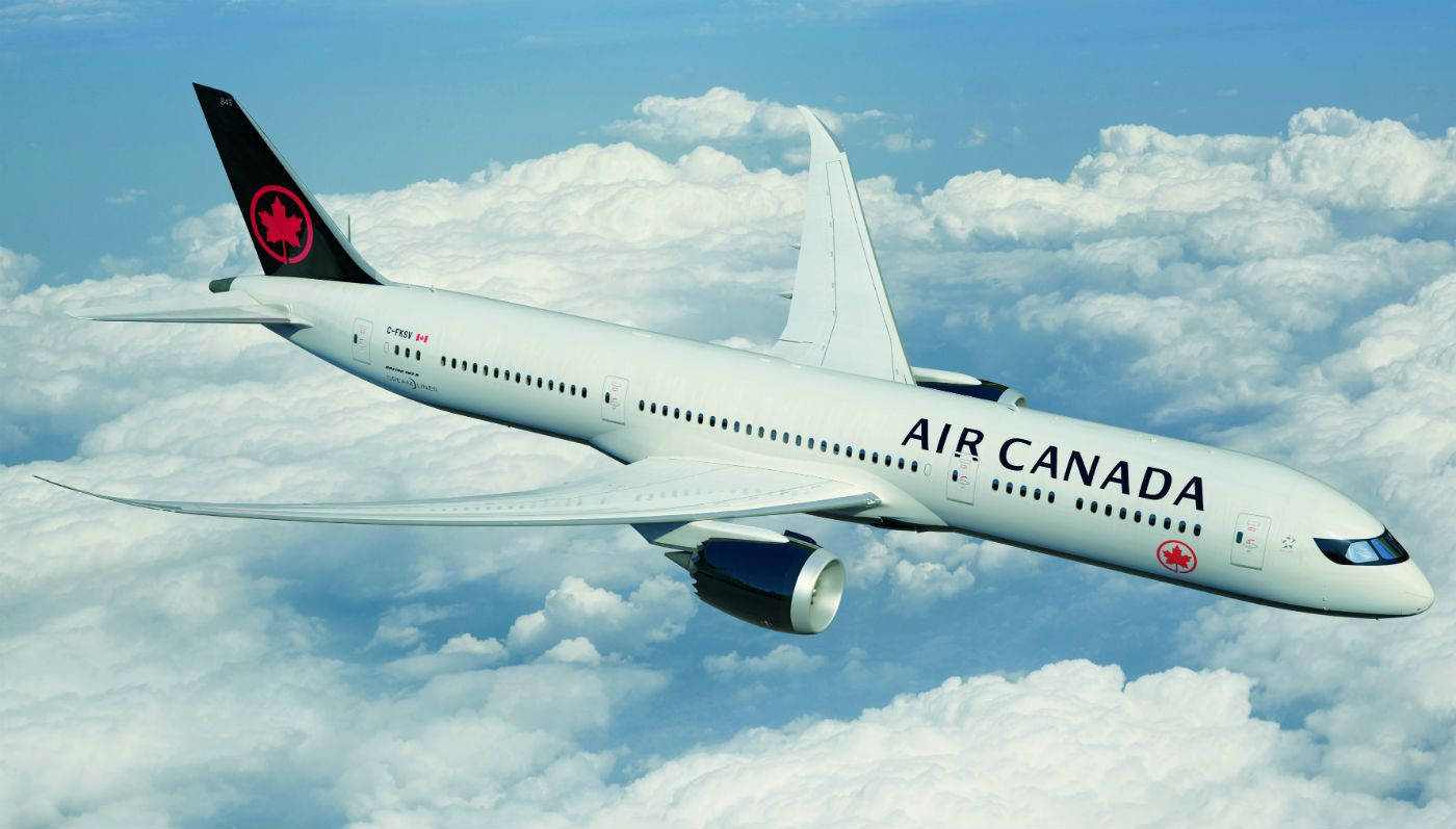 飛機 桌布 壁紙 — 一架加拿大航空飛機在晴朗藍天下優雅地翱翔於蓬鬆白雲之上。