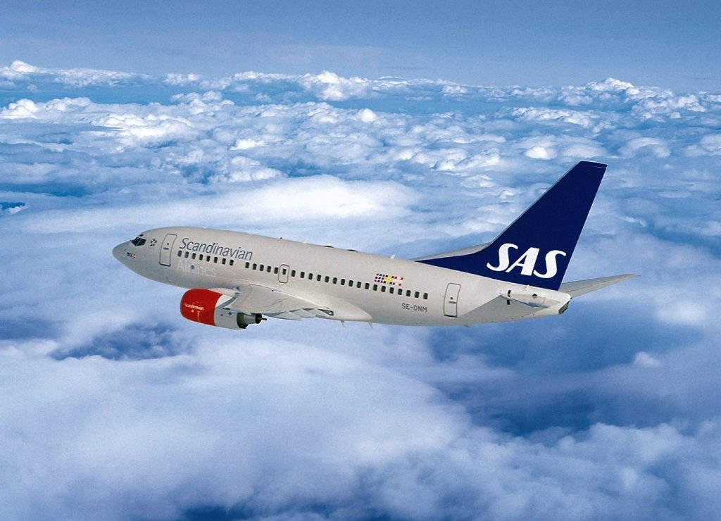 飛機 桌布 壁紙 — 一架北歐SAS客機在晴朗藍天下優雅地翱翔於一片蓬鬆白雲之上。