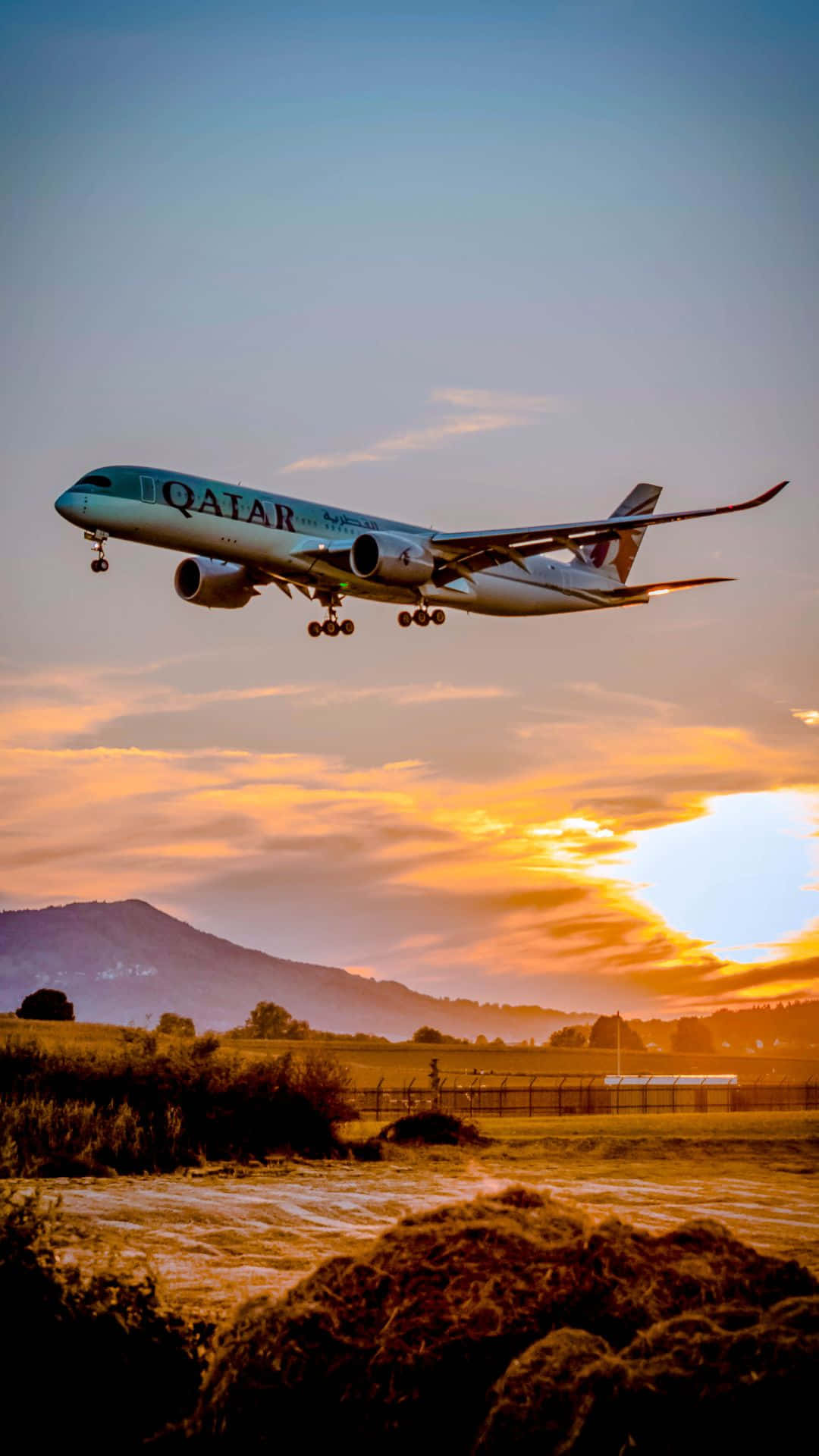 卡塔爾航空飛機在日落時分降落在山丘和田野上 — 飛機 壁紙