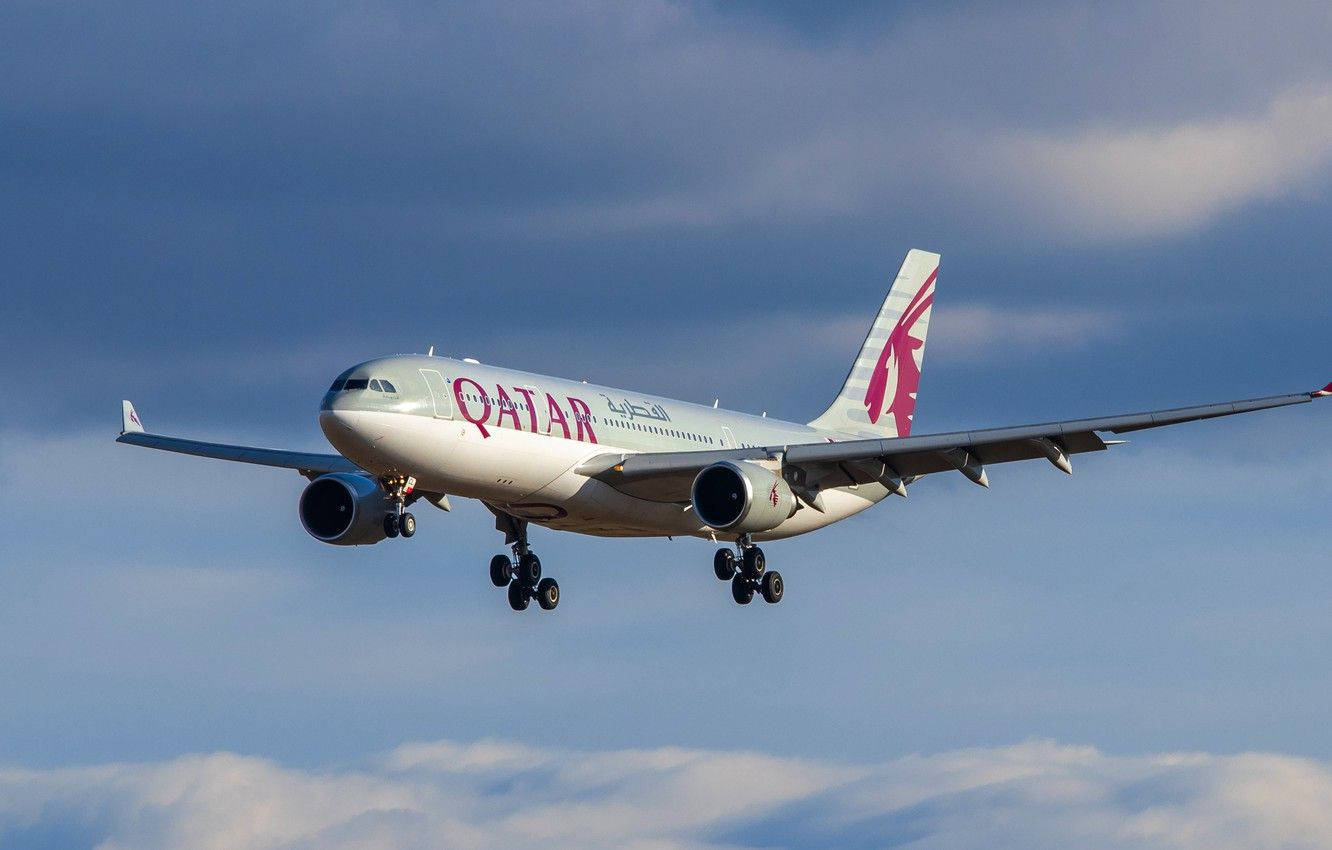  壁紙 — 一架卡達航空的空中巴士A330正在降落，起落架放下，背景是部分多雲的藍天。