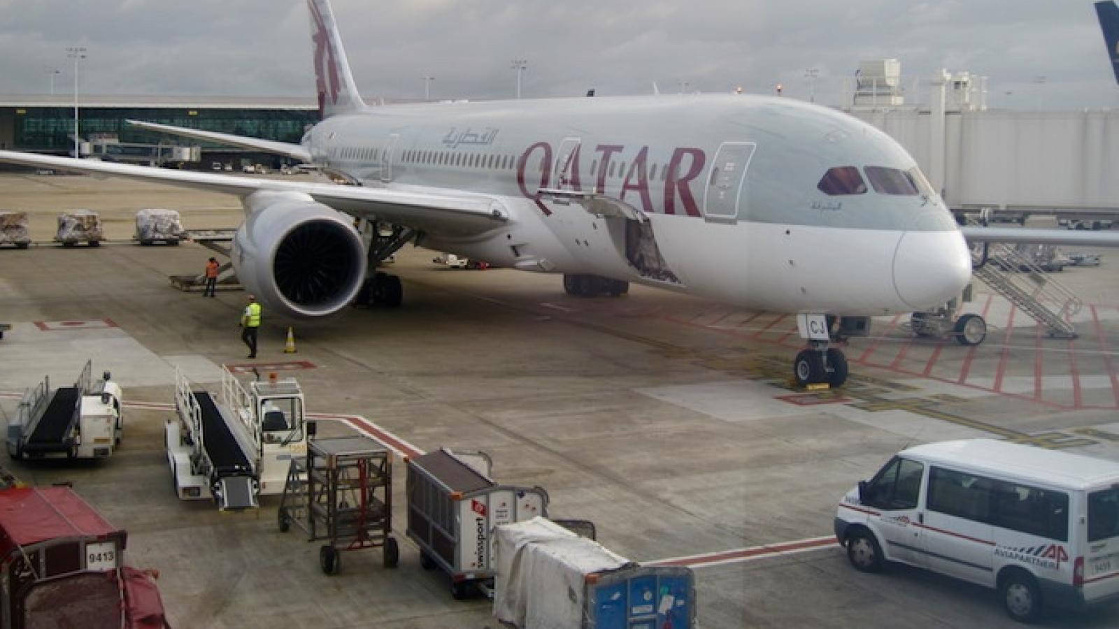 Qatar 桌布 壁紙 — 一架卡達航空空中巴士A350停泊在機場閘口，地勤人員和服務車輛圍繞著它，天空多雲。