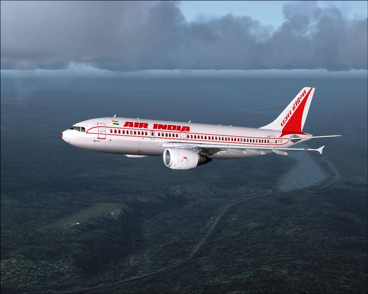 風景 桌布 壁紙 — 一架印度航空客機在雲層密佈的天空和綠色地形上空翱翔，下方可見跑道。