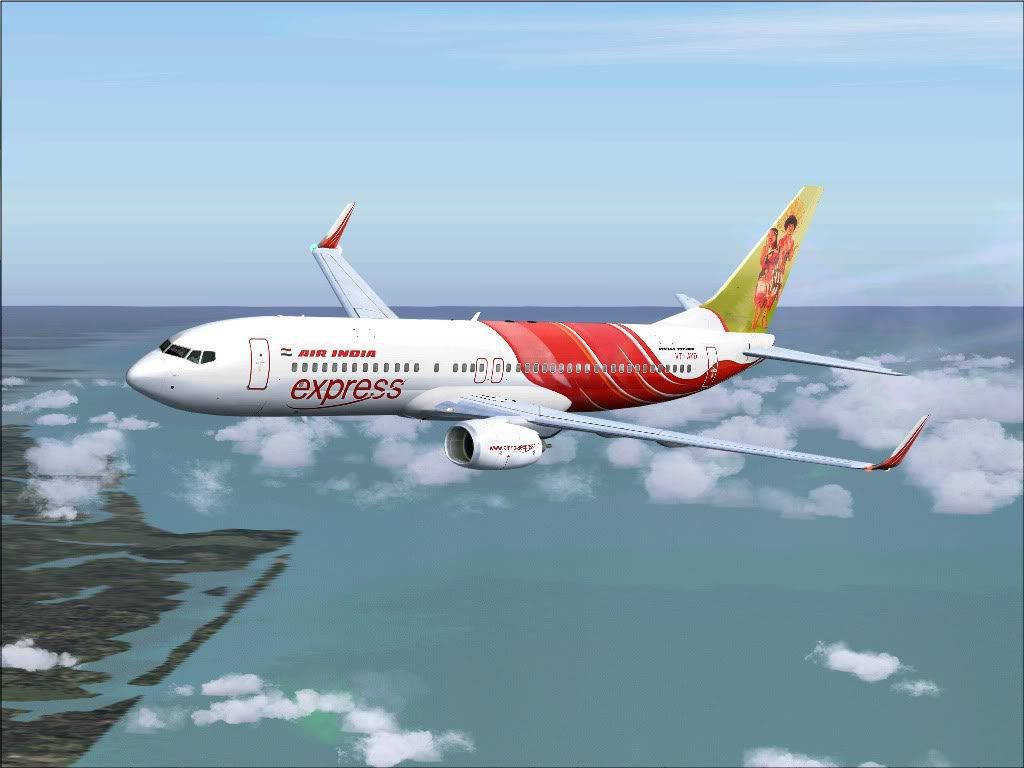 飛機 桌布 壁紙 — 一架印度航空快運飛機在碧綠色的海洋上空，在蓬鬆的雲層之上翱翔，下方可見陸地。