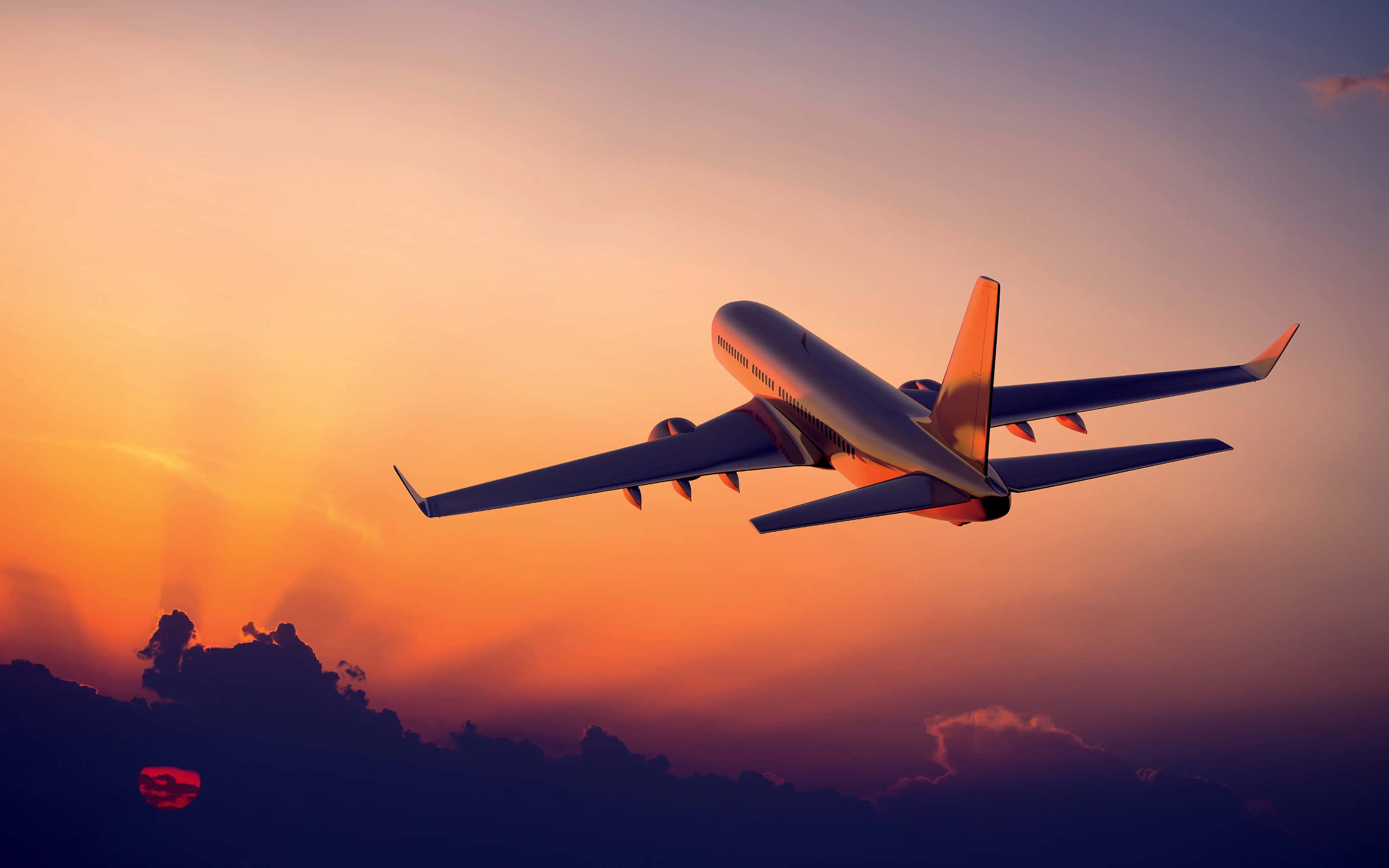 Plane 桌布 壁紙 — 一架商用飛機在充滿活力的橙紫色調日落天空和下方剪影雲層中翱翔。