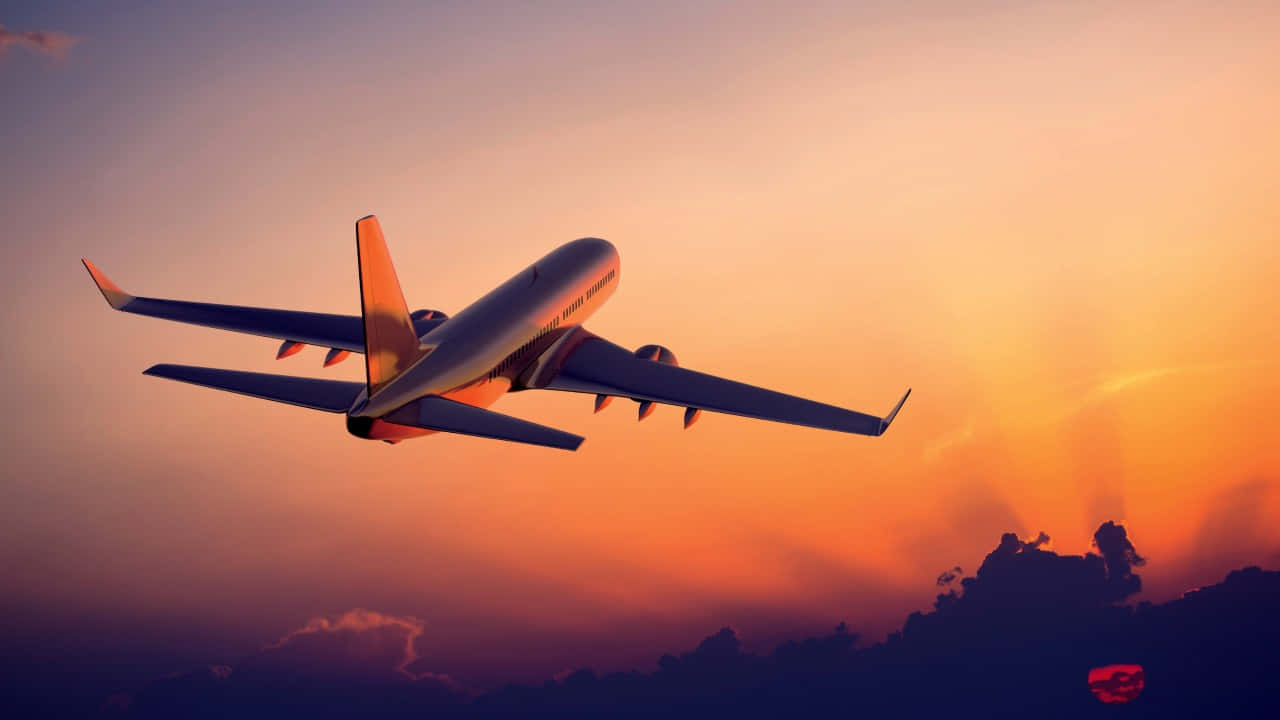 720p Plane 桌布 壁紙 — 一架商用飛機在橙紫交織的絢麗日落天空中翱翔，下方是輪廓分明的雲層。