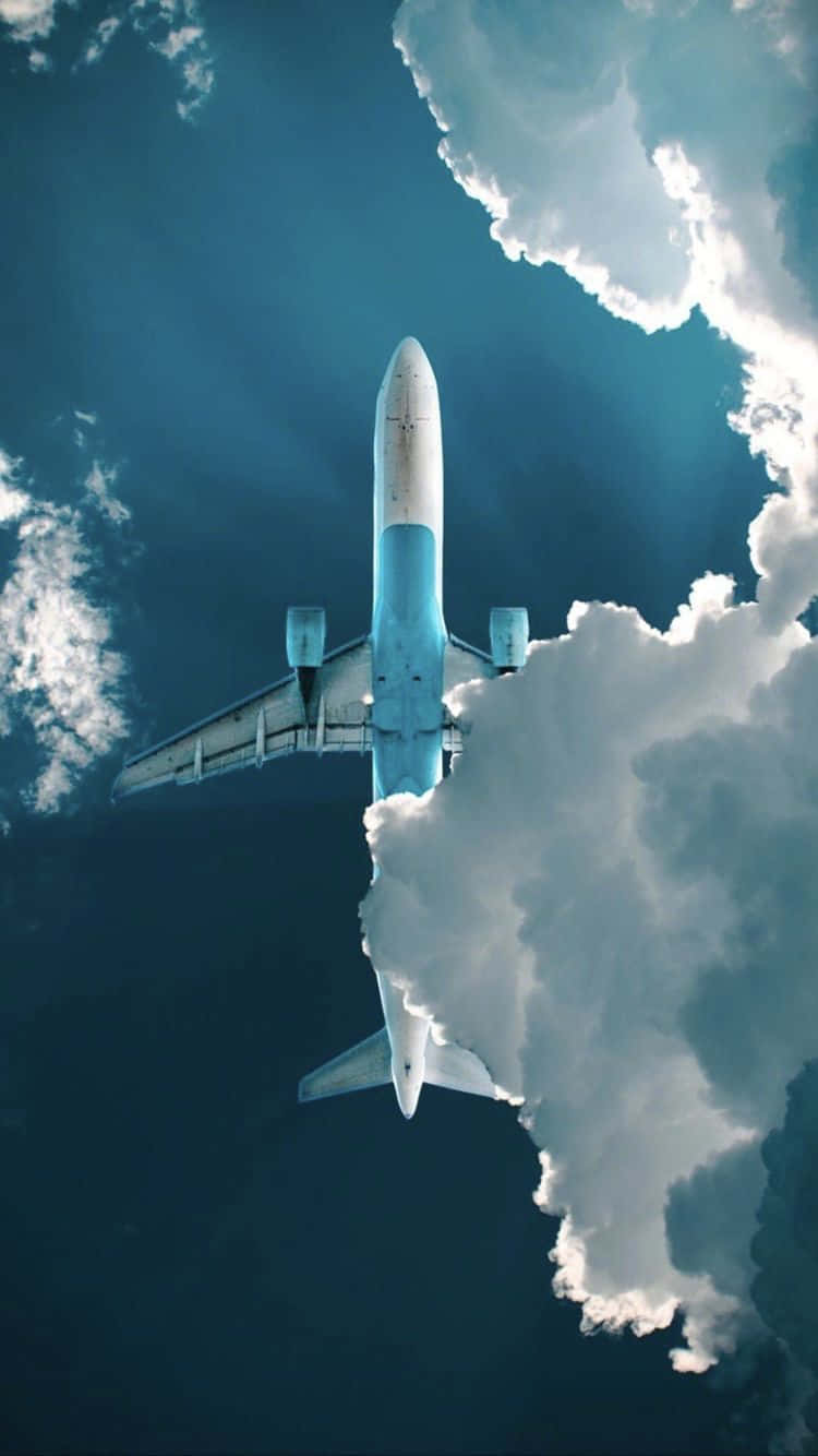 飛機 桌布 壁紙 — 一架商用飛機在深藍色的天空中翱翔，下方襯托著戲劇性的白雲。