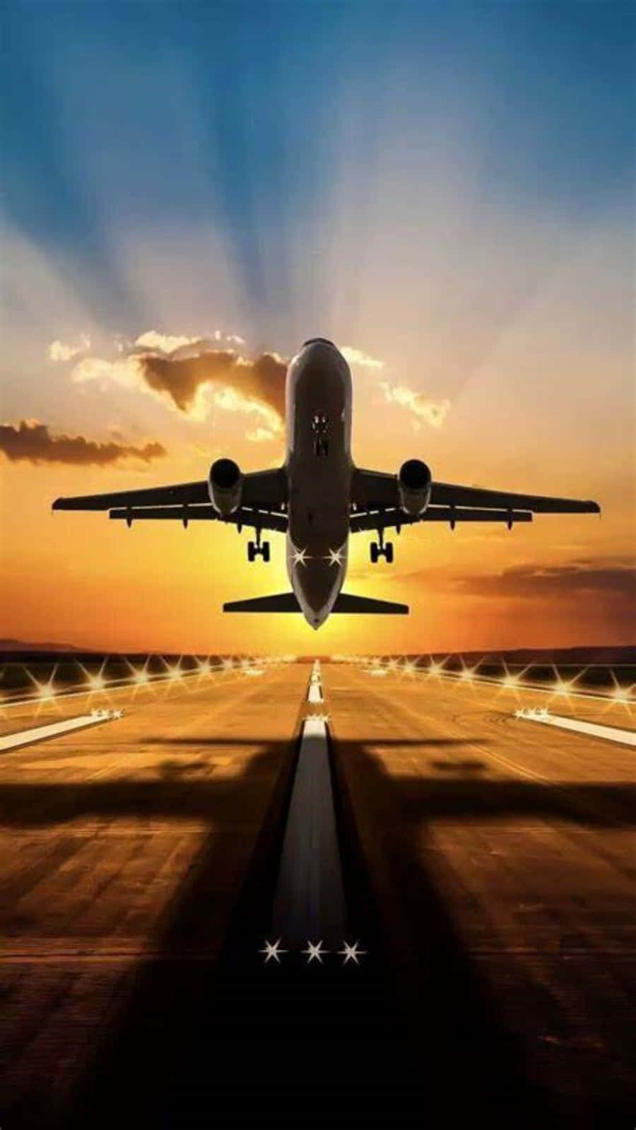 飛機 桌布 壁紙 — 一架商用飛機正降落到被金色夕陽和戲劇性天空光線籠罩的跑道上。