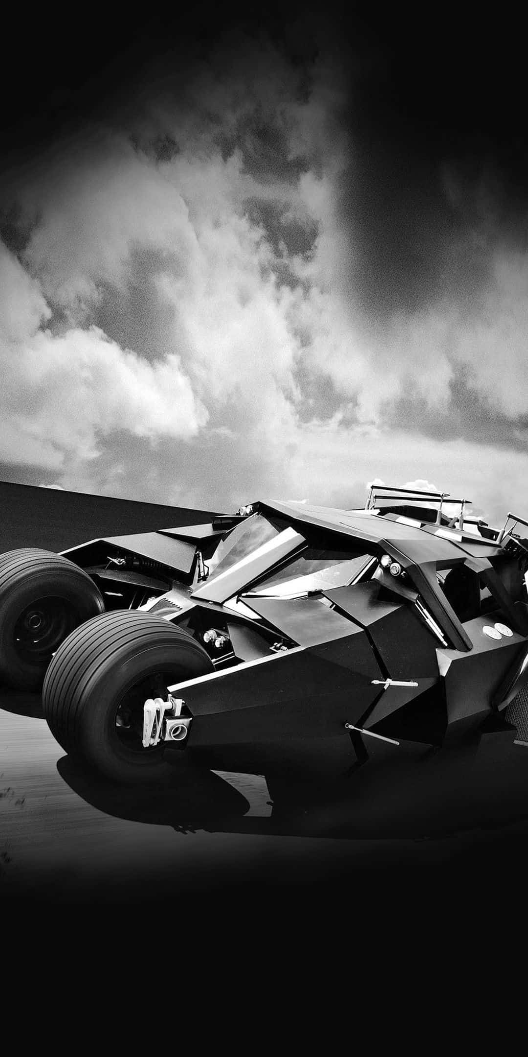 Pixel 3 Batmobile 桌布 壁紙 — 一架單色蝙蝠車在暴風雨的天空下，以戲劇性的燈光和銳利的幾何線條戲劇性地停放。