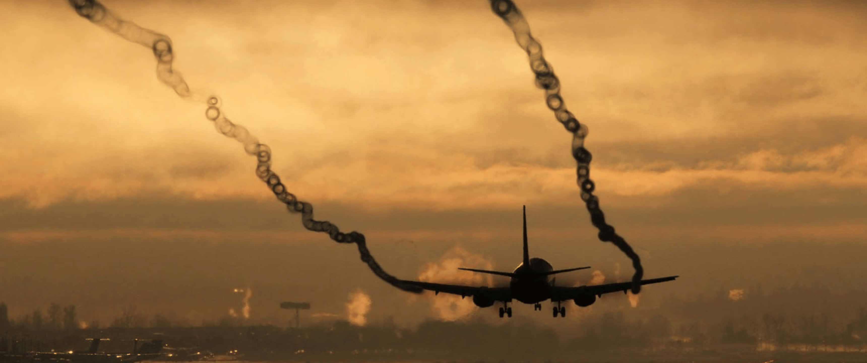 Plane 桌布 壁紙 — 一架噴射機在金色夕陽天空的襯托下呈現剪影，在降落時拖出環狀煙霧。