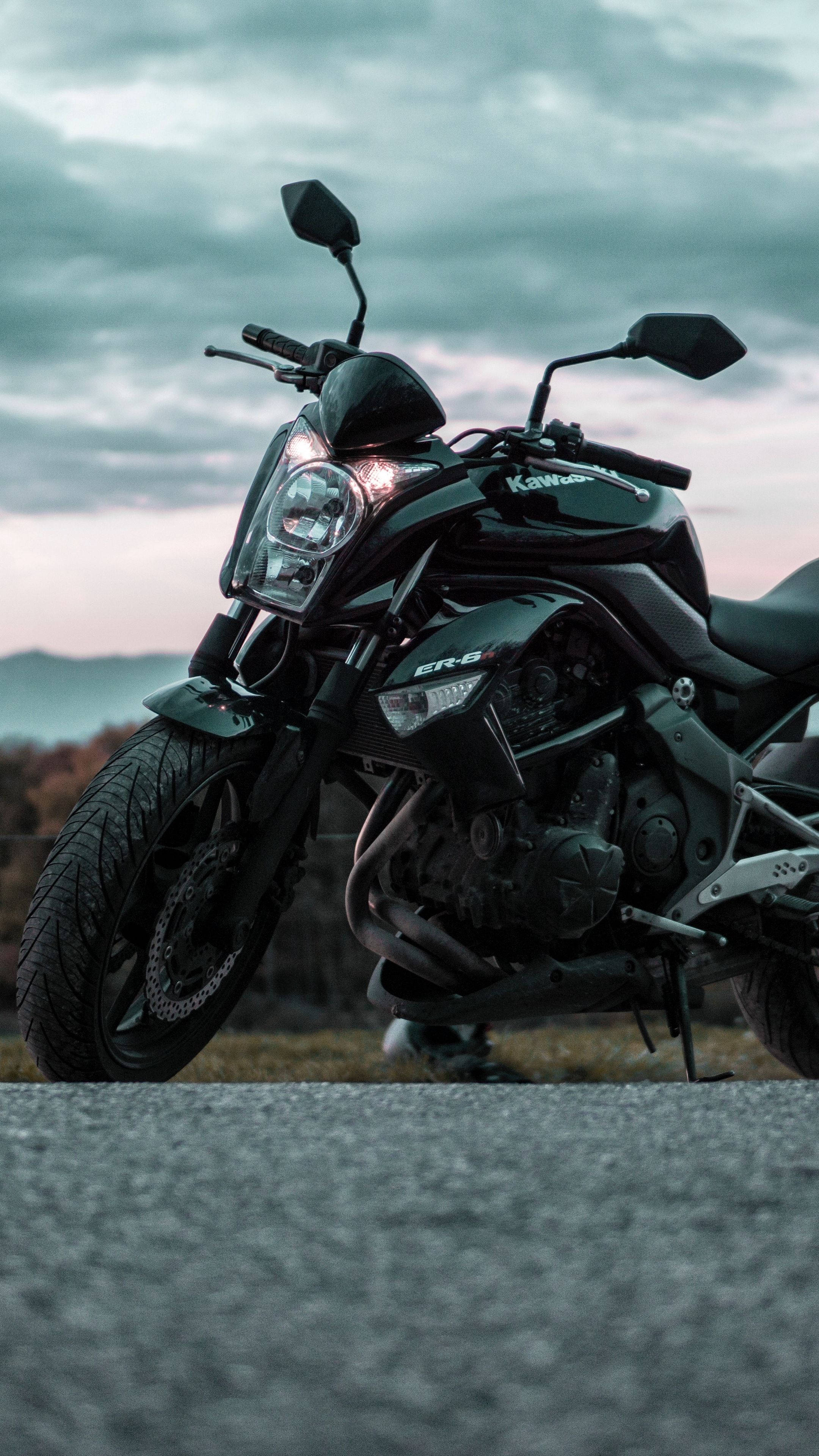 4K bike 桌布 壁紙 — 一架型格黑色Kawasaki ER-6機車停泊在柏油路上，背景是陰沉的暮色天空和遠山。